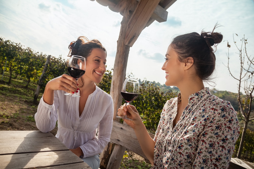 Two women drinking red wine at the best wineries in the Willamette Valley